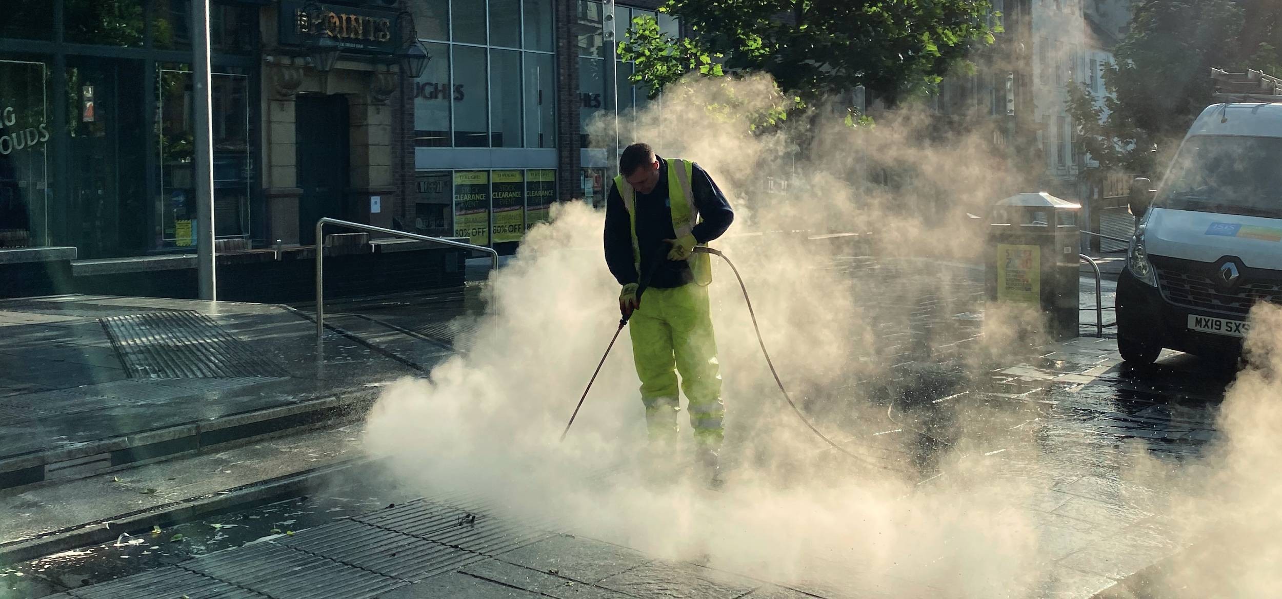 A member of the NE1 Clean Team jetwashing